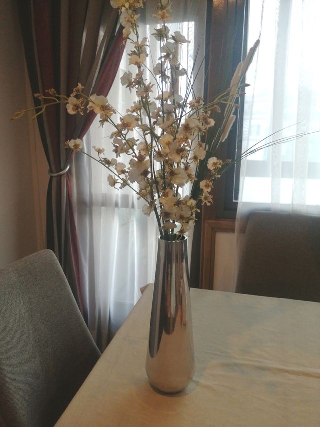 Florero de metal con flores artificiales