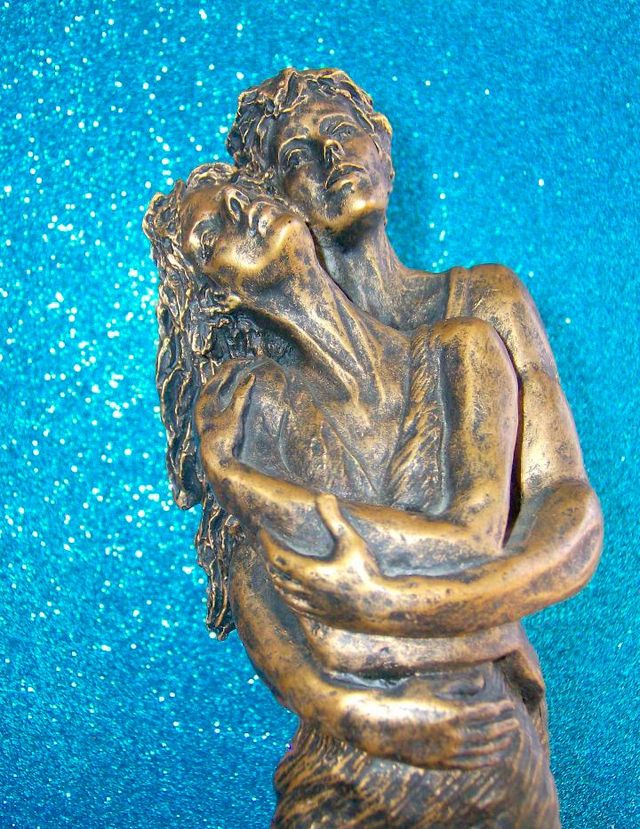 FIGURA PAREJA ENAMORADOS ABRAZADOS SOBRE UNA ROCA