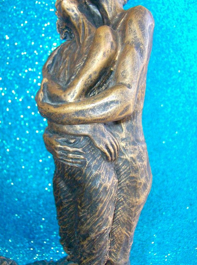 FIGURA PAREJA ENAMORADOS ABRAZADOS SOBRE UNA ROCA