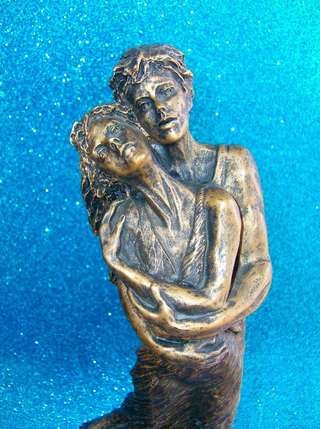 FIGURA PAREJA ENAMORADOS ABRAZADOS SOBRE UNA ROCA