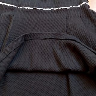Falda negra de tablas, tela relieve estilo piqué