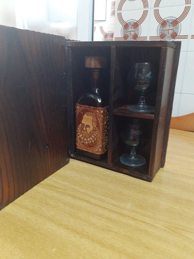 Libro de madera con copas y botella licorera