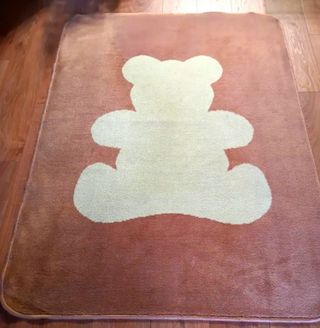 Tappeto marrone. Silhouette di orso beige a pelo corto