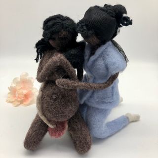 Muñeca negra embarazada dando a luz con la matrona