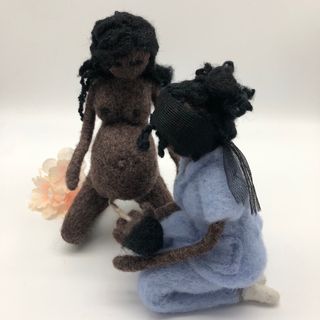 Muñeca negra embarazada dando a luz con la matrona