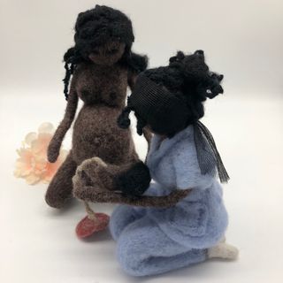 Muñeca negra embarazada dando a luz con la matrona