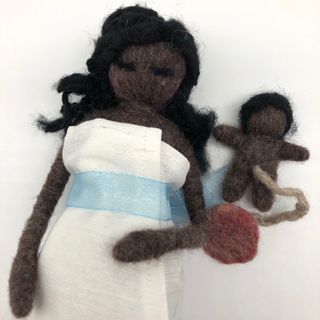 Muñeca negra embarazada dando a luz con la matrona