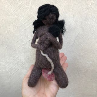 Muñeca negra embarazada dando a luz con la matrona