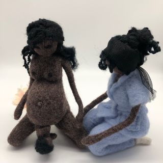 Muñeca negra embarazada dando a luz con la matrona