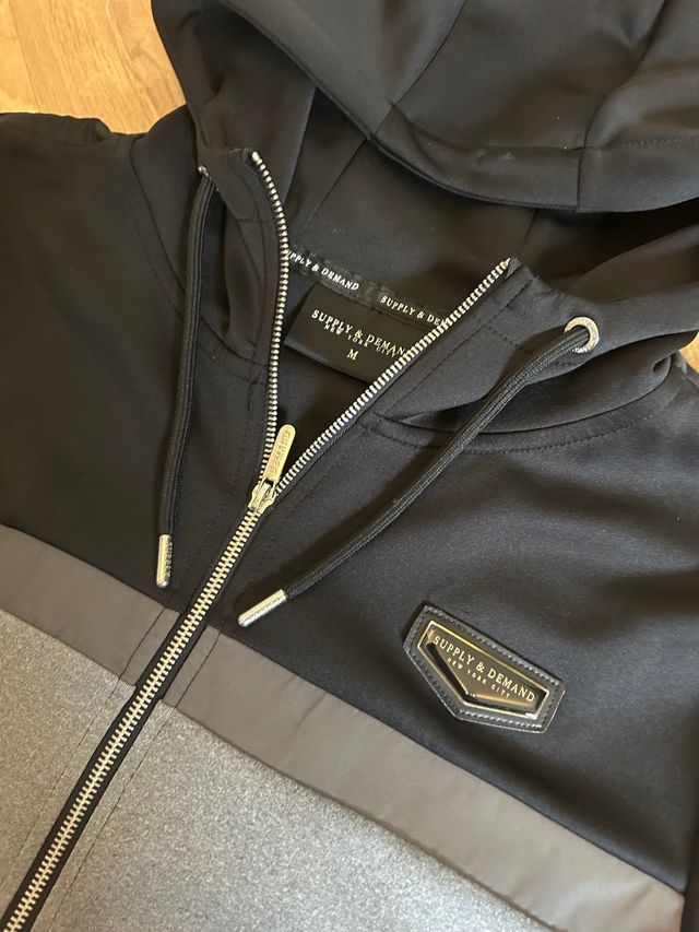 Sudadera negra y gris Supply & Demand