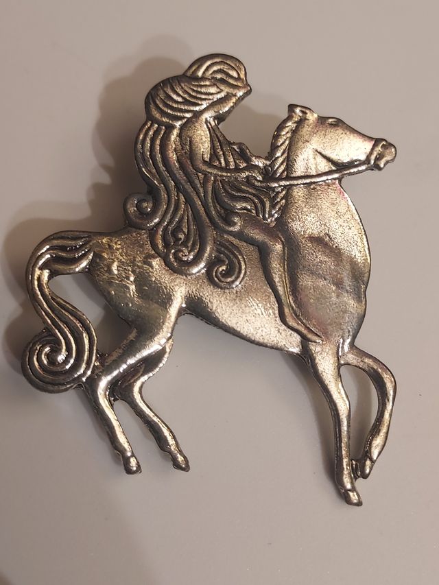 Broche de mujer con pelo largo cabalgando caballo