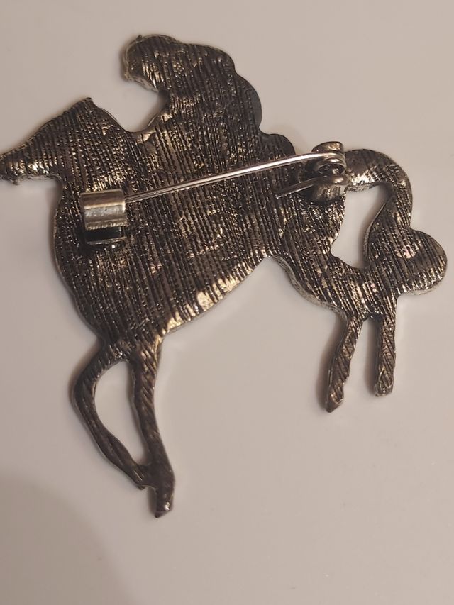 Broche de mujer con pelo largo cabalgando caballo