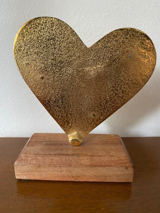 Cuore colore dorato, con base in legno.