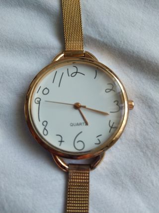 Reloj dorado, gran esfera,números irregu