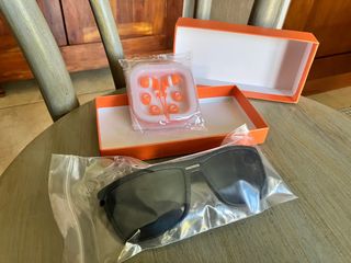 occhiali da sole neri e auricolari