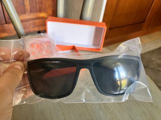 occhiali da sole neri e auricolari