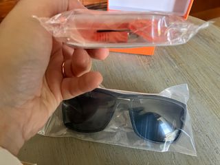 occhiali da sole neri e auricolari