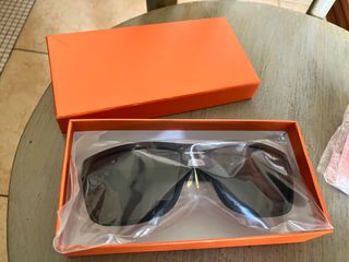 occhiali da sole neri e auricolari