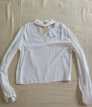 BLUSA MANGA LARGA CON ADORNOS.