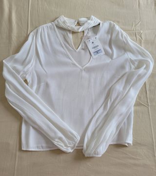 BLUSA MANGA LARGA CON ADORNOS.
