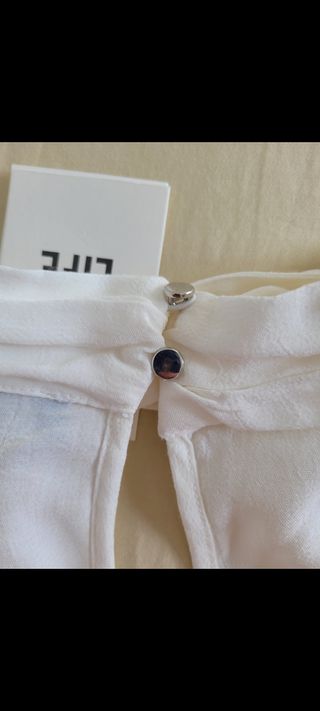 BLUSA MANGA LARGA CON ADORNOS.