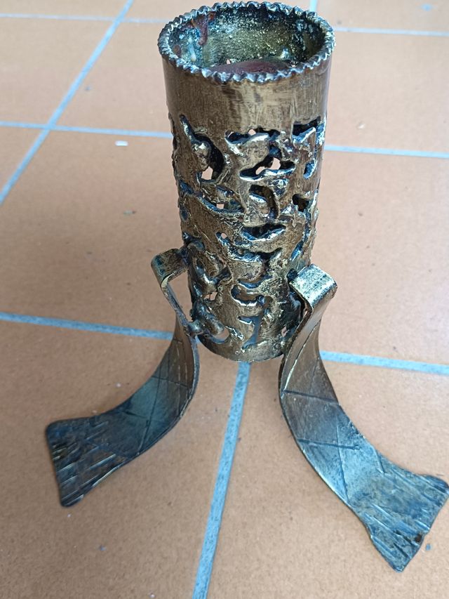 Portavelas metálico dorado para una vela.