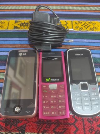 Dos móviles antiguos y un cargador