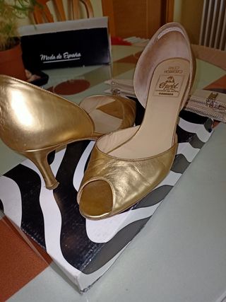 Zapatos tacón dorados y bolso de mano