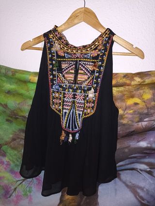 Blusa negra con detalles étnicos.