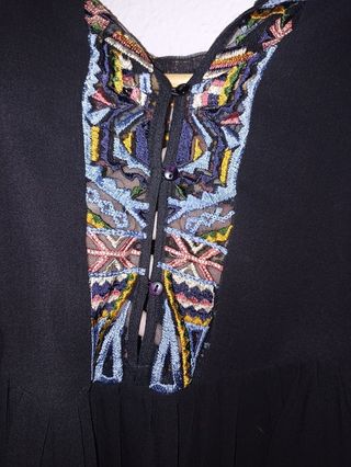 Blusa negra con detalles étnicos.