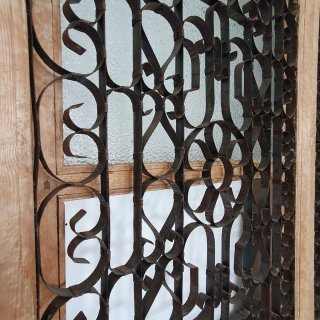 Puerta antigua con celosía filigrana de hierro