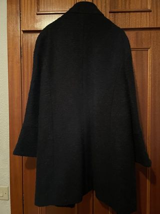 Abrigo negro de mangas acampanadas.