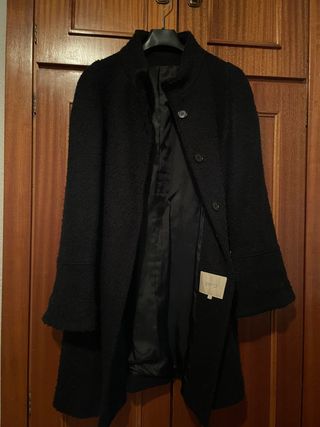 Abrigo negro de mangas acampanadas.