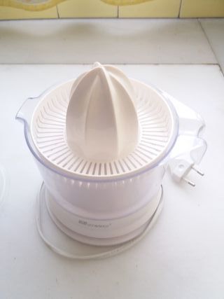 un exprimidor eléctrico y otro manual de cristal