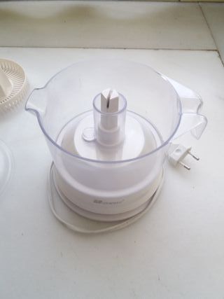 un exprimidor eléctrico y otro manual de cristal