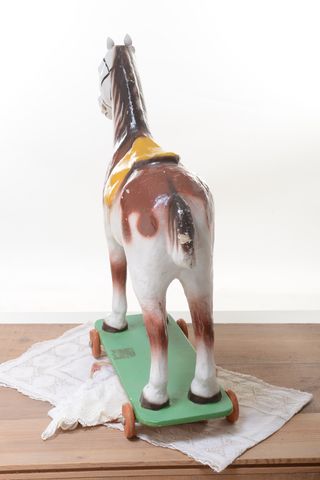 Caballo vintage de juguete de cartón sobre ruedas