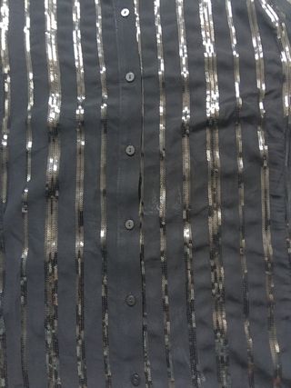 Blusa negra con lentejuelas. Mango