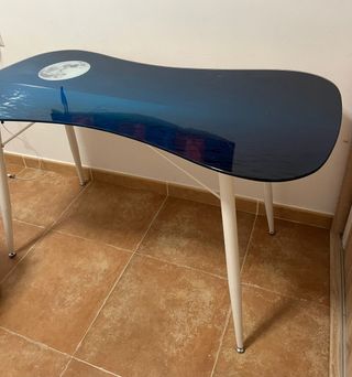 Mesa con superficie de vidrio, patas metálicas.