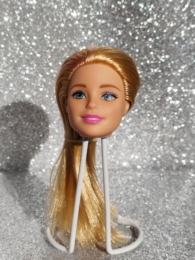 Cabeza rubia Barbie con mancha roja.