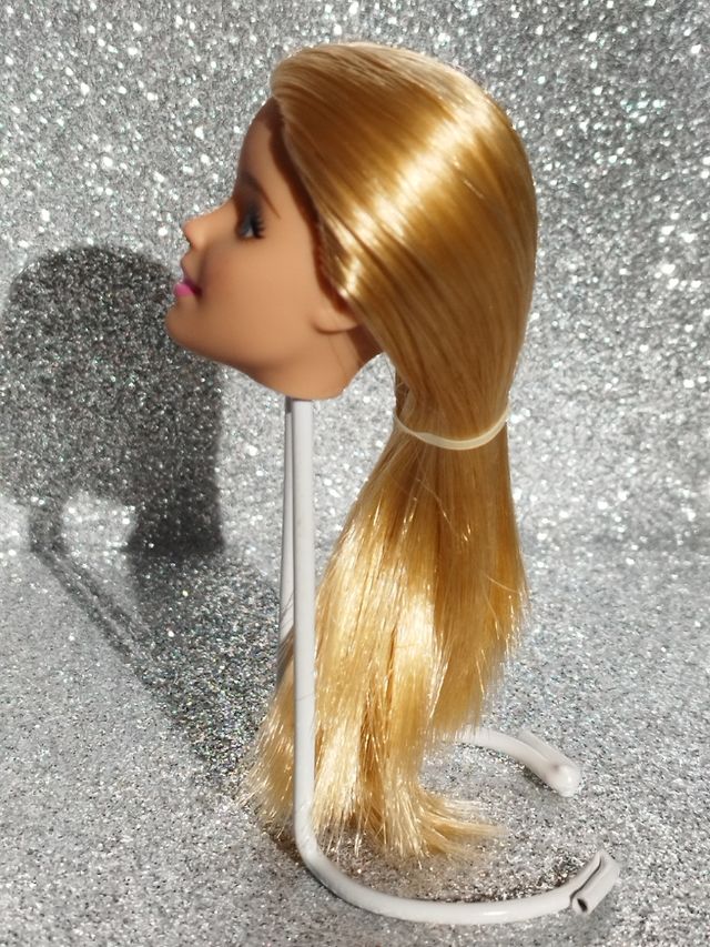 Cabeza rubia Barbie con mancha roja.