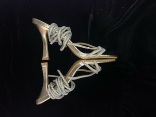 Sandalias oro con tiras de brillantes.
