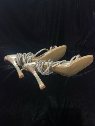 Sandalias oro con tiras de brillantes.