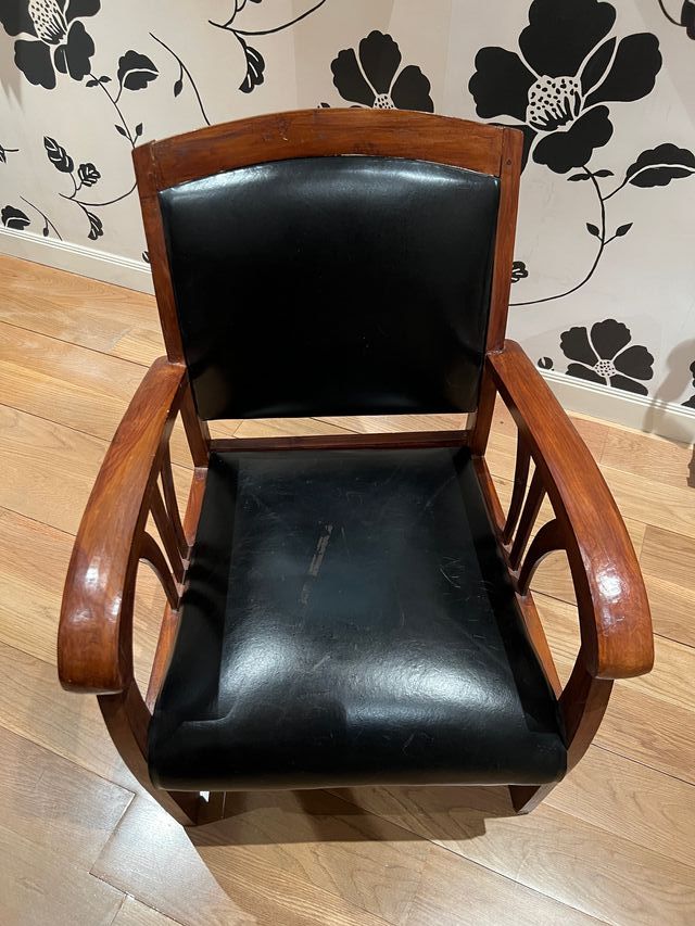 Butaca de madera y cuero negro.