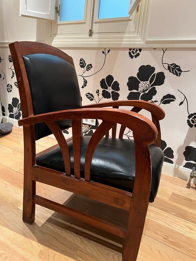 Butaca de madera y cuero negro.