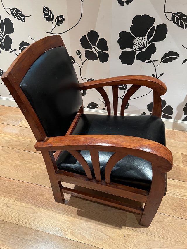 Butaca de madera y cuero negro.