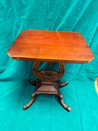 Elegante mesa auxiliar con pie forma de arpa.