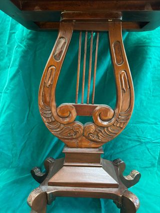 Elegante mesa auxiliar con pie forma de arpa.