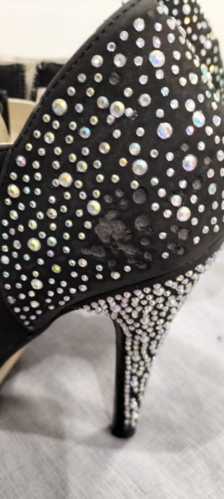 Zapatos negros con tacón brillante.