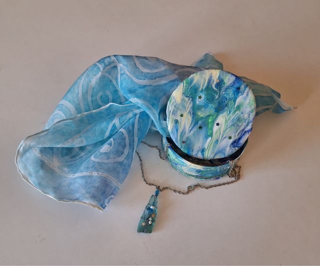 cofre artesanal con pañuelo de seda y colgante.