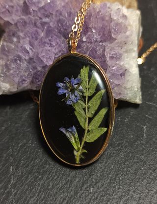 Colgante ovalo dorado de resina con flor morada